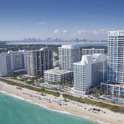On the beach, white sand, sun loungers, beach umbrellas