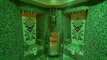 Experience the unique mosaic tile design and enjoy a relaxing space with a glass partition, bench, and towel rack.