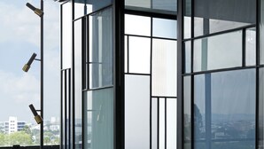Un intérieur moderne avec de grandes fenêtres en verre, un sol réfléchissant et une chaise blanche au design minimaliste.