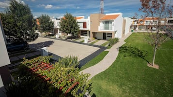 Residential area with modern architecture, well-maintained lawns, and large windows.