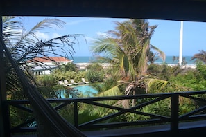Une piscine entourée de palmiers et un bâtiment avec un toit rouge.