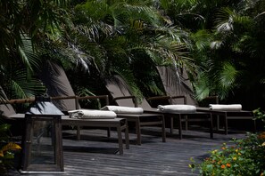 Um terraço com espreguiçadeiras e um candeeiro.