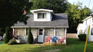 A single-story house with a front porch, a small deck, and a mailbox.