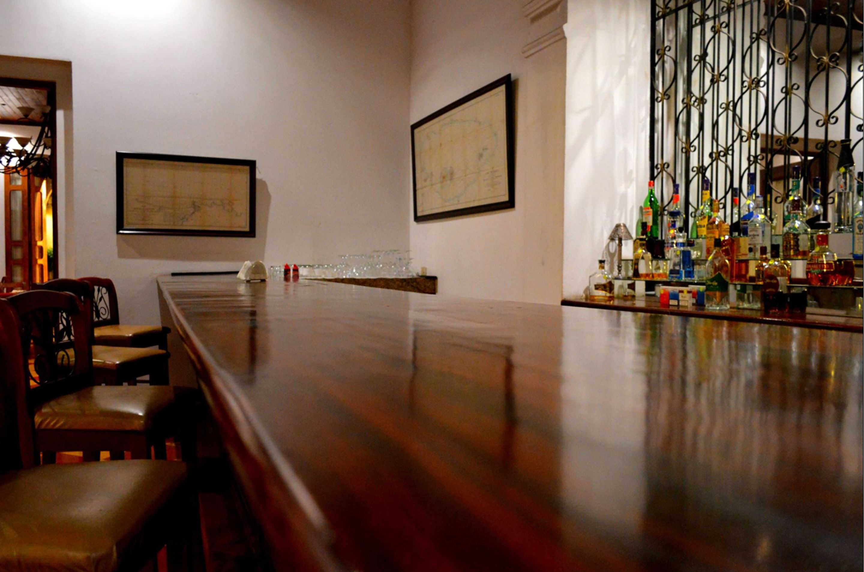 Un salón de conferencias con una larga mesa, sillas y una zona de bar con varias botellas.