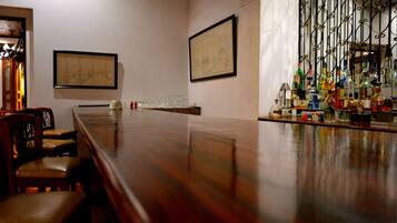 Un salón de conferencias con una larga mesa, sillas y una zona de bar con varias botellas.
