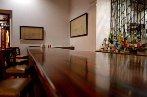 Un salón de conferencias con una larga mesa, sillas y una zona de bar con varias botellas.