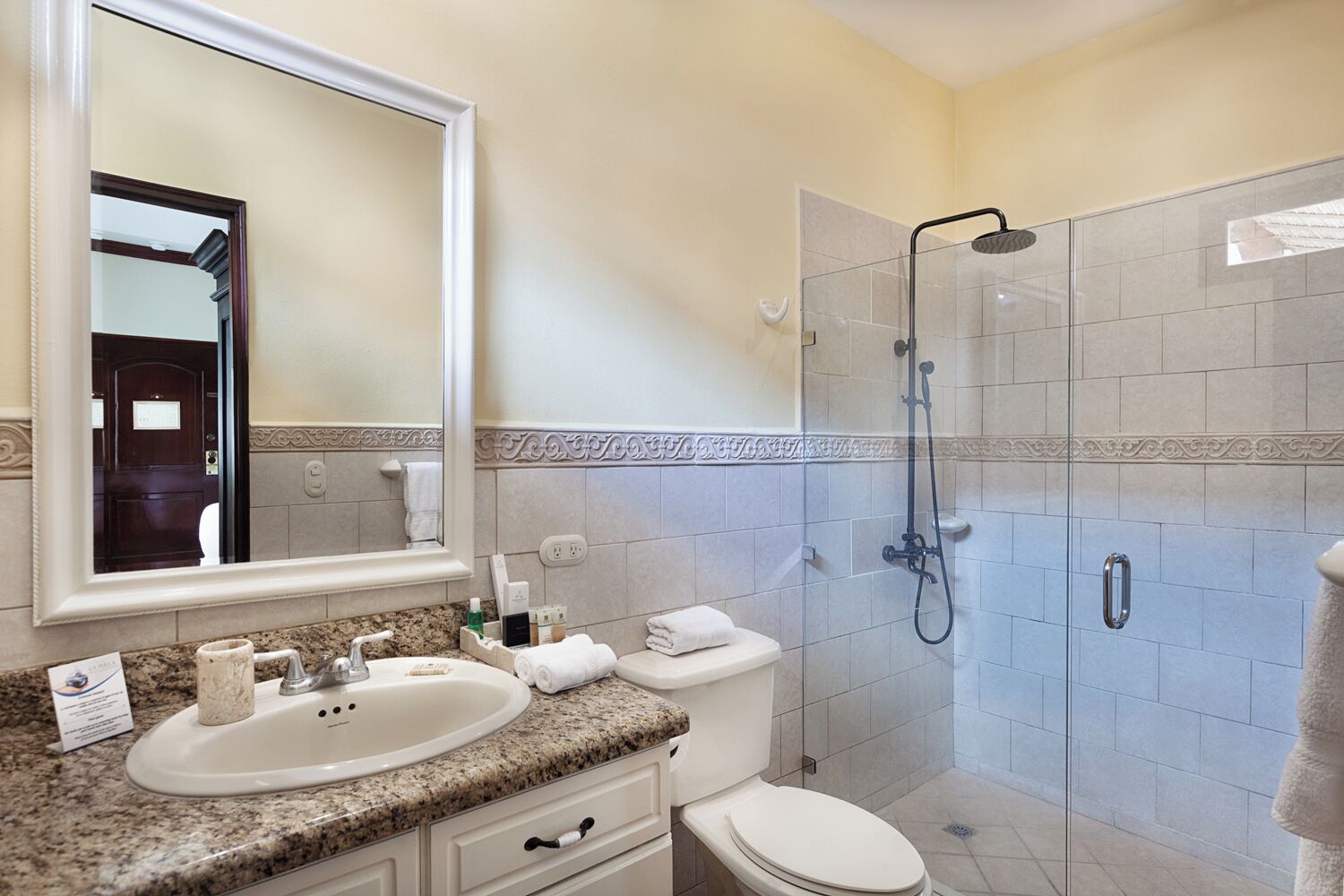 A bathroom with a sink, toilet, and shower.