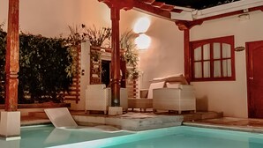 A swimming pool with lounge chairs and a pergola. - Hotel La Perla (León)
