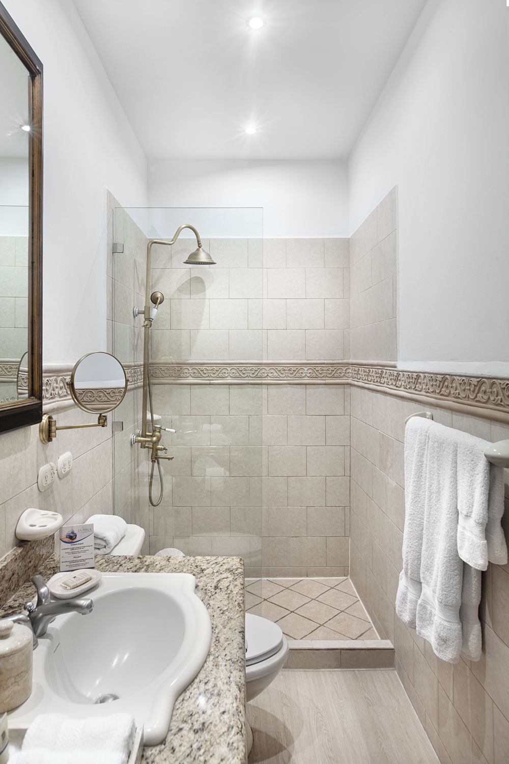 A modern bathroom with a sink, toilet, and shower.