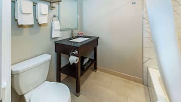 A bathroom with a toilet, sink, and mirror.