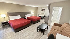 Una habitación de hotel con dos camas, un escritorio, una silla y un sofá.