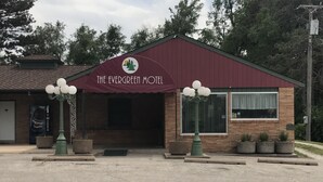 Le motel Evergreen, avec son auvent bordeaux, sa façade en briques et sa grande fenêtre.