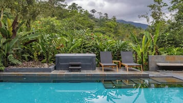 Una piscina al aire libre, sillones reclinables de piscina