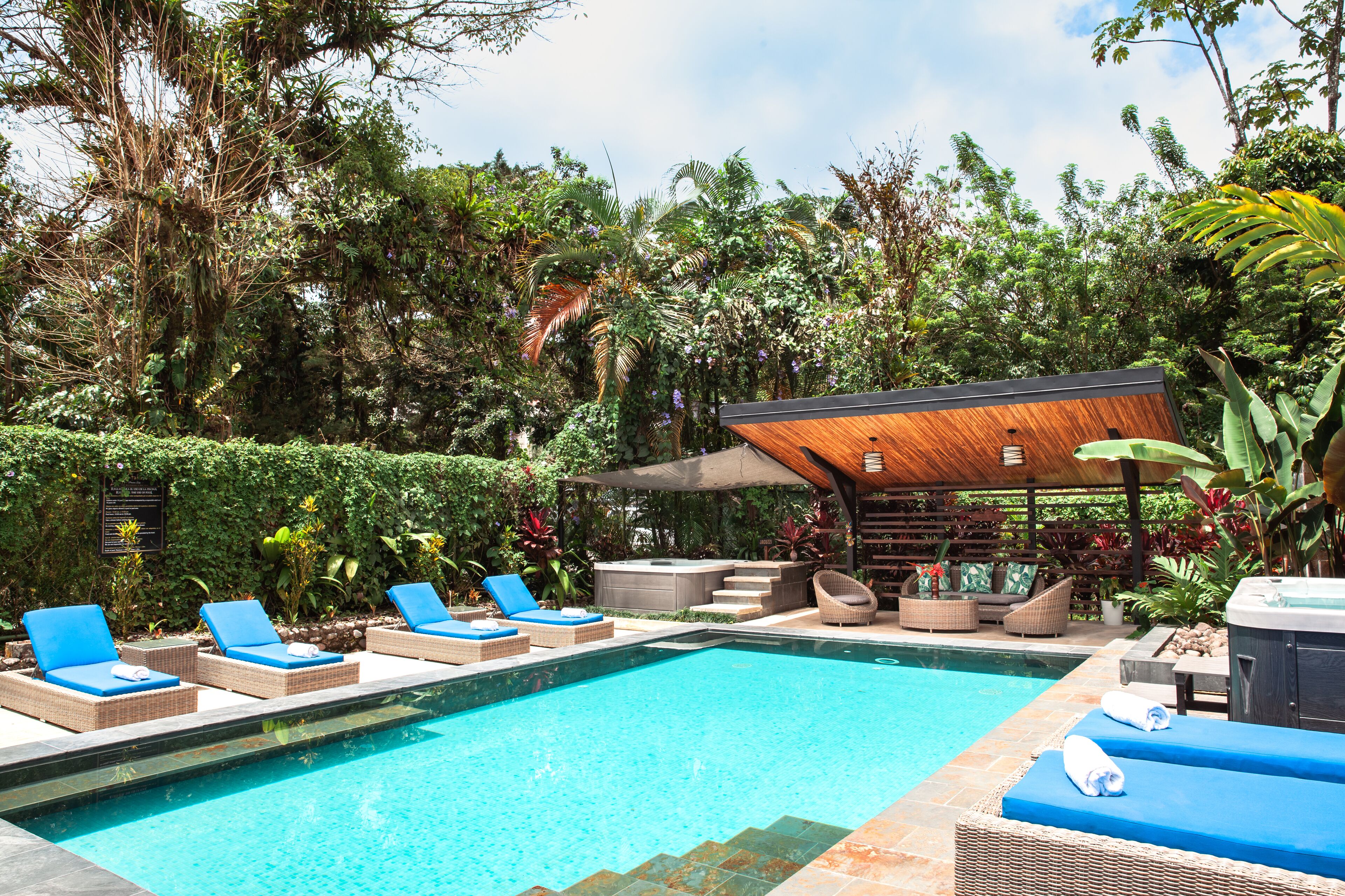 Una piscina al aire libre, sillones reclinables de piscina