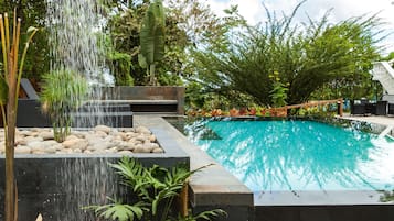 Una piscina al aire libre, sillones reclinables de piscina