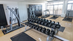A gym with exercise equipment, a treadmill, and dumbbells. - Just Enjoy Business Hotel (Tainan)