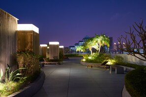 A rooftop terrace with seating areas, plants, and a city skyline in the background. - Taipung Suites (Tainan)