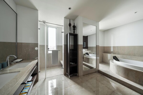 Une salle de bain moderne avec un grand miroir, une baignoire et un espace douche.