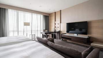 Een moderne hotelkamer met een groot bed, een bureau, een televisie en een bank.