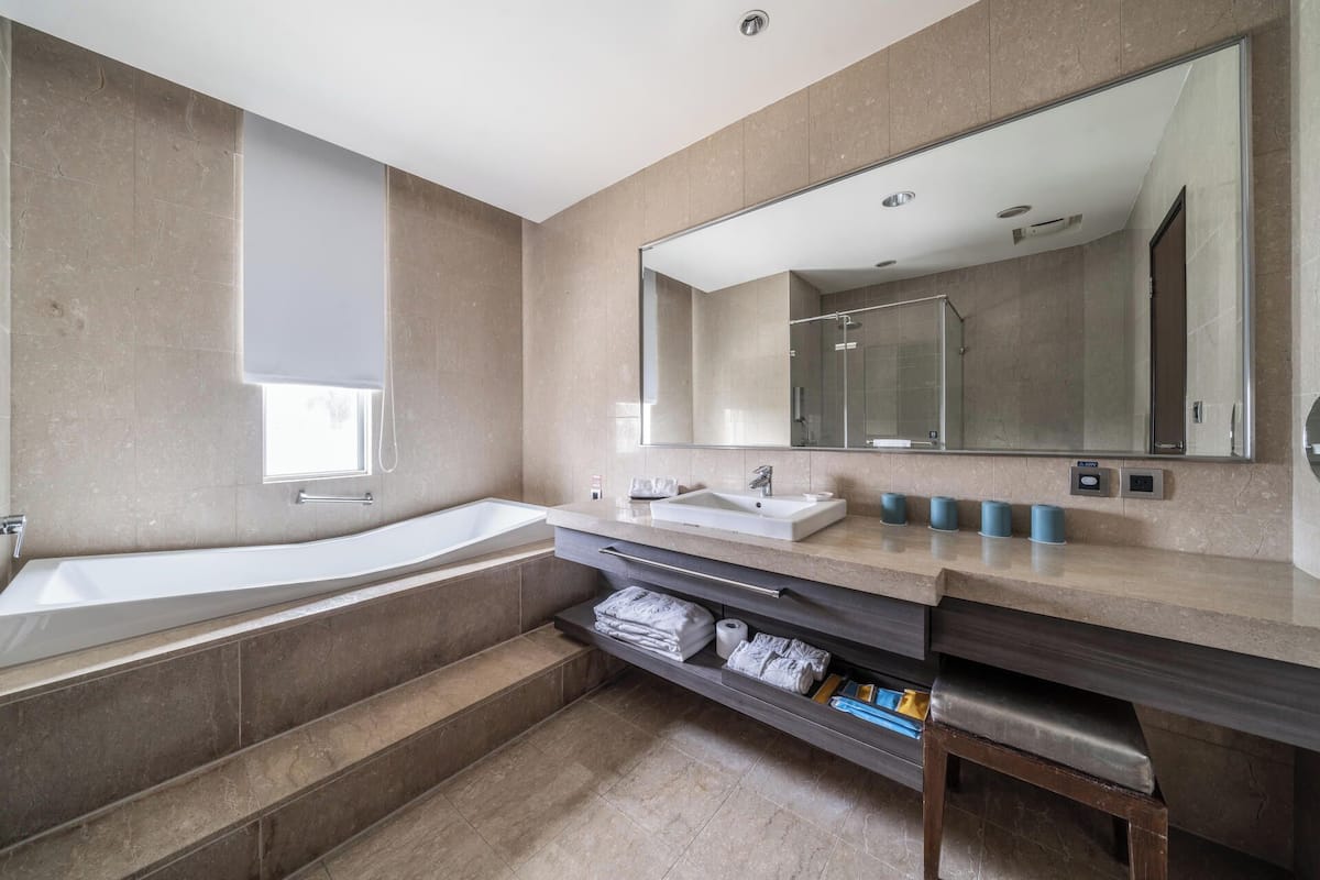 deluxe quadruple room | bathroom | separate bathtub and shower, deep-soaking bathtub