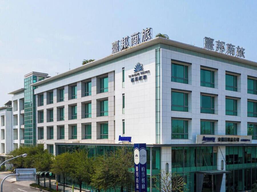 A modern building with multiple windows and a sign indicating it is a hotel.