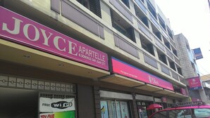 A multi-story building with a visible storefront for 'JOYCE PARTELLE' and 'Philippine Savings Bank'.