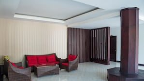 A modern interior with a sectional sofa, two armchairs, and a tall pillar. - Saysamphanh Hotel (Luang Prabang)