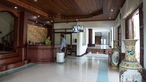 A hotel lobby with a reception desk, a staircase, and decorative vases. - Saysamphanh Hotel (Luang Prabang)