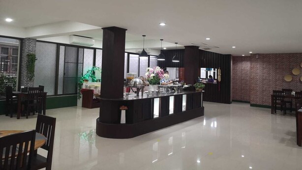 A spacious hotel lobby with a central bar area, seating arrangements, and a brick wall. - Saysamphanh Hotel (Luang Prabang)