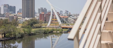 Un paisaje urbano con un río, un puente moderno y rascacielos.