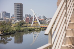 Paisagem urbana com rio, uma ponte moderna e edifícios altos.