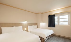 Hotellihuone, jossa on kaksi sänkyä, ikkuna, jossa on verhot, ja kattovalaisin.