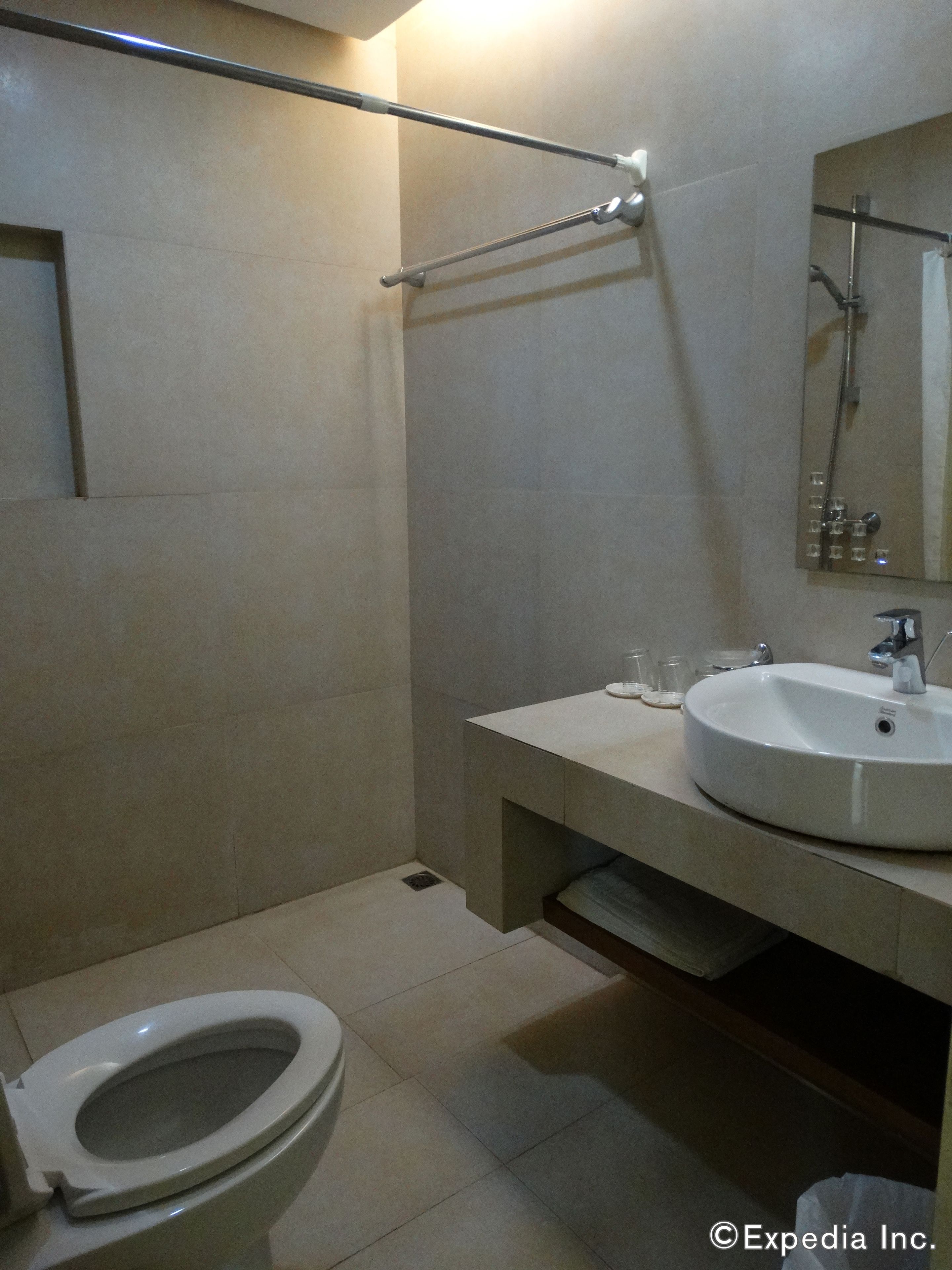 Un baño con inodoro, lavamanos y zona de ducha.