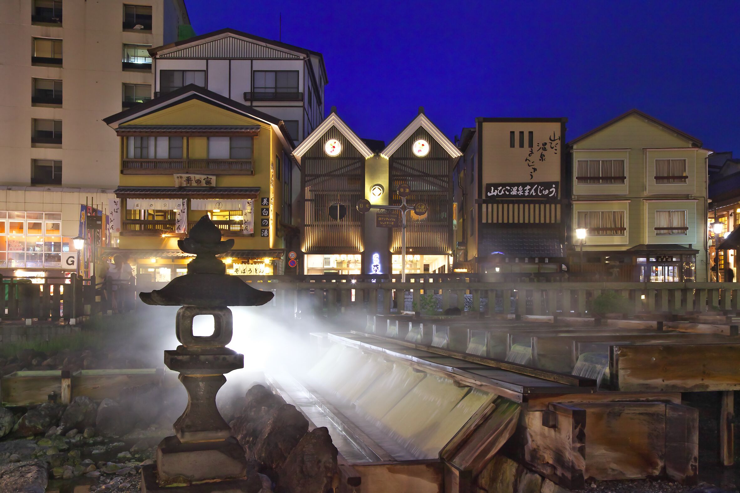 A traditional Japanese building with a wooden structure and a clock on the facade.