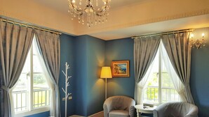 A hotel room with a large bed, two armchairs, a small table, a lamp, and a chandelier. - Haut-Rhin Villa (Zhuangwei)