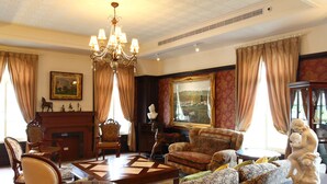 A traditional living room with a fireplace, patterned sofas, a glass coffee table, and a chandelier. - Haut-Rhin Villa (Zhuangwei)