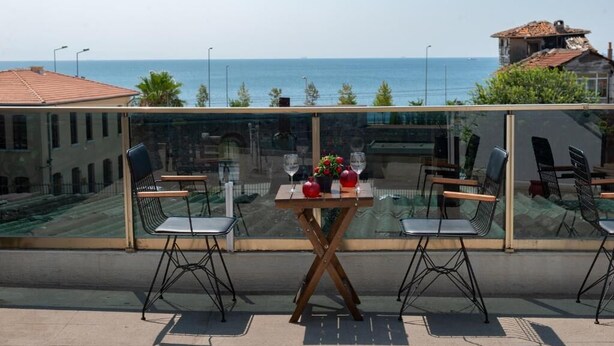 Un balcón con mesa y sillas, con vista al mar.