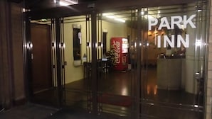 Entrada de un hotel con una máquina expendedora de Coca-Cola y un mostrador de recepción.