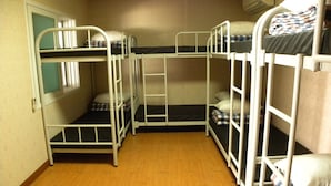 A room with bunk beds, wooden flooring, and a window with blinds. - Kame House - Hostel (Seoul)