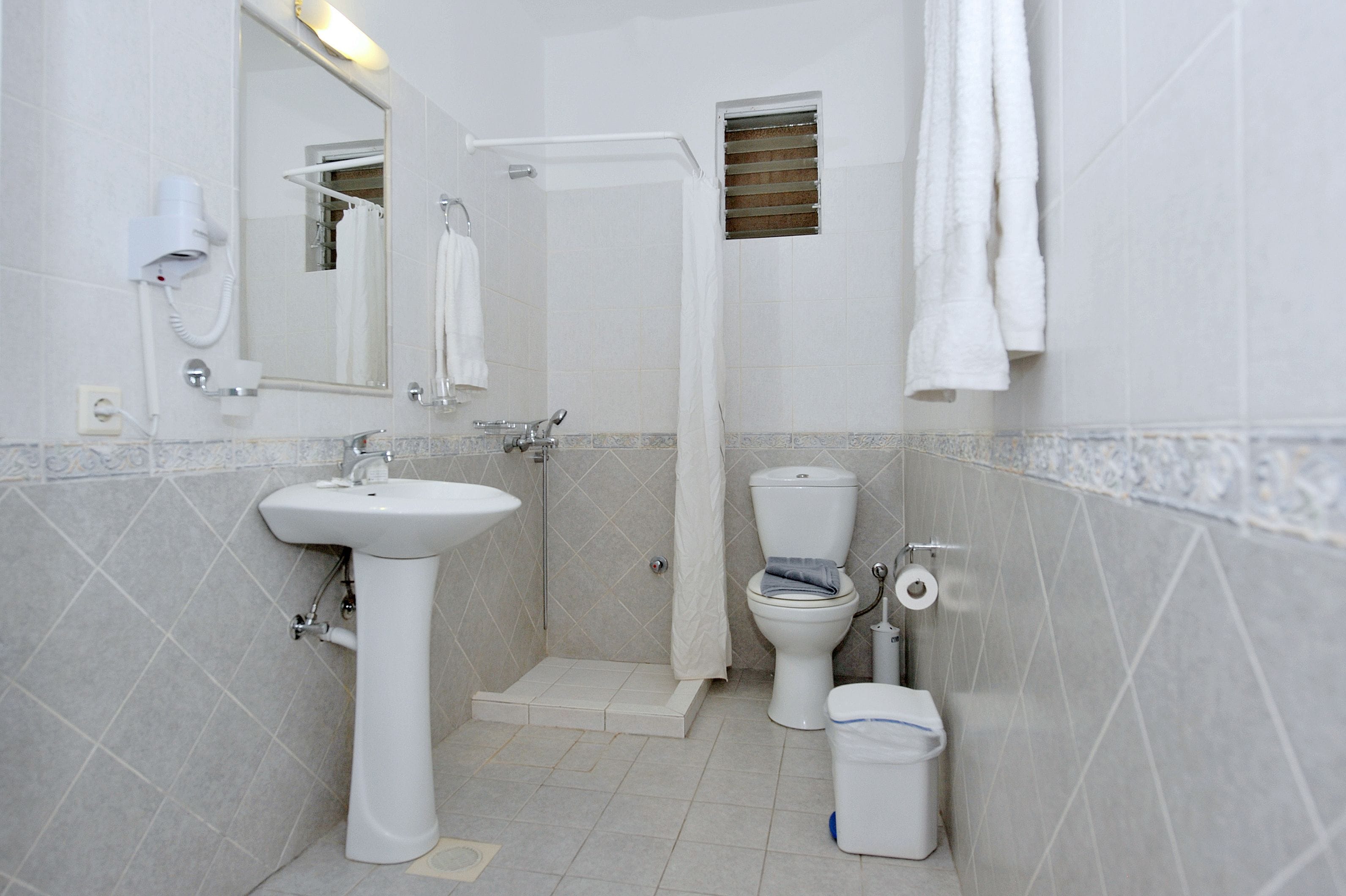 A bathroom with a sink, toilet, and shower.
