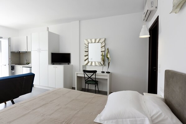 Una habitación de hotel moderna con una cama, un escritorio, una silla y un televisor.