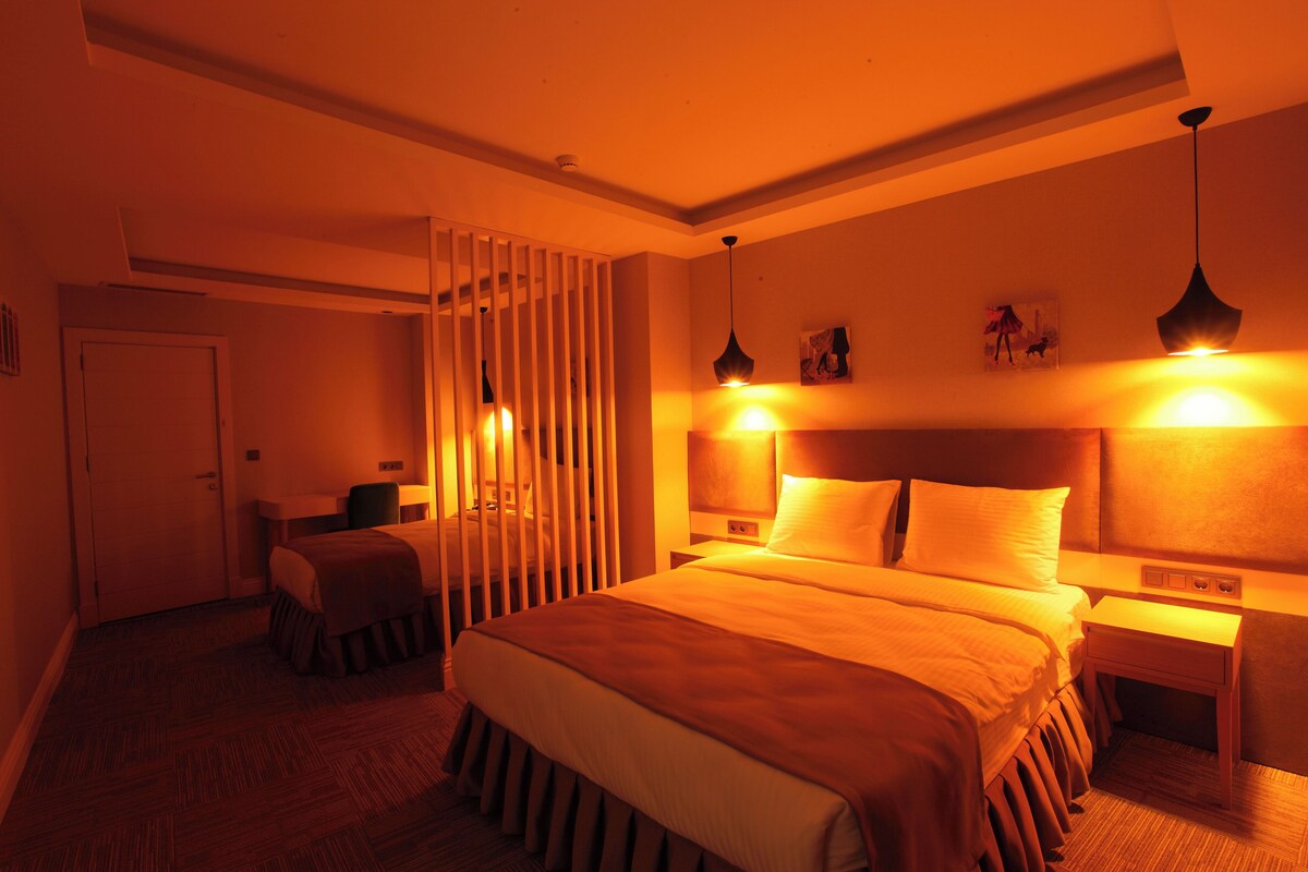 Une chambre d’hôtel avec un grand lit, des tables de chevet, un bureau et une chaise.
