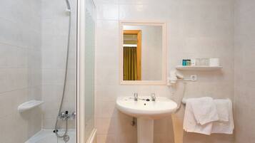 Ein Badezimmer mit Badewanne, Dusche, Waschbecken und Spiegel.