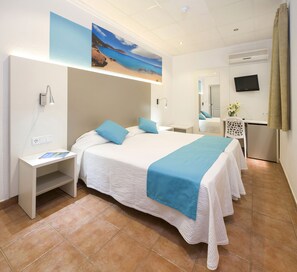 A hotel room with a bed, a desk, a chair, a TV, and a painting of a beach scene. - Hostal Residencia Adelino (Sant Antoni de Portmany)