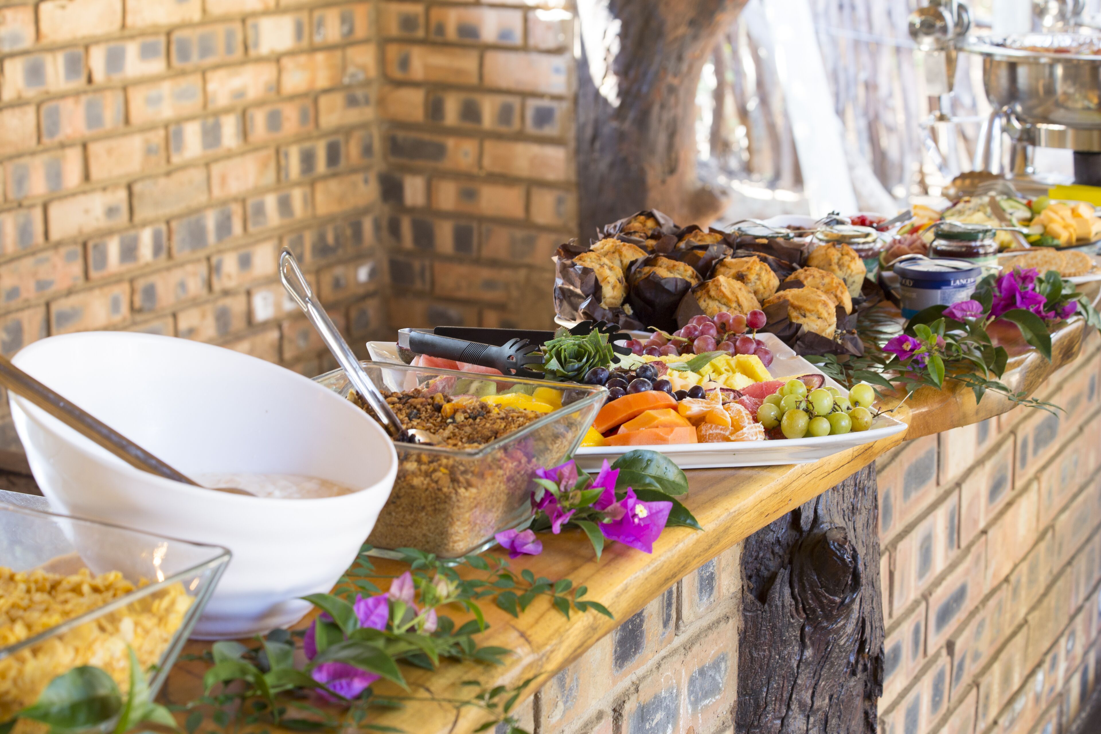 Una mesa de buffet con diversos alimentos y un tazón blanco.