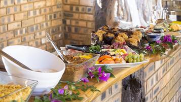 Una mesa de buffet con diversos alimentos y un tazón blanco.