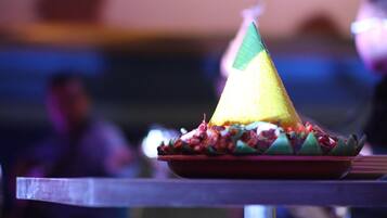 A table with a plate of food, including a yellow cone-shaped item and a red plate.