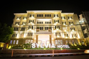 Un hôtel doté d’une entrée imposante et sur lequel on peut lire l’inscription « HÔTEL SYLVIA ».