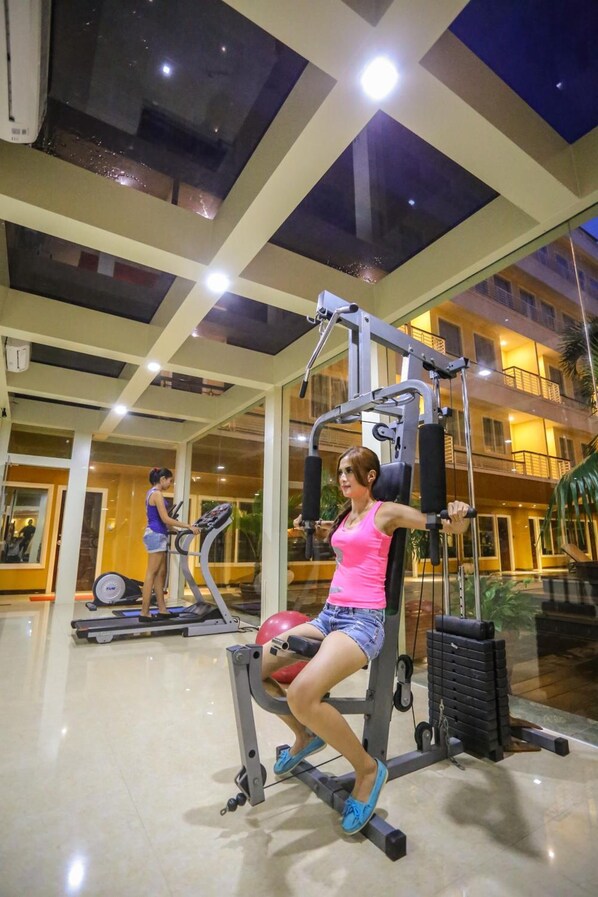 Un gimnasio con equipamiento de ejercicio y techo de vidrio.