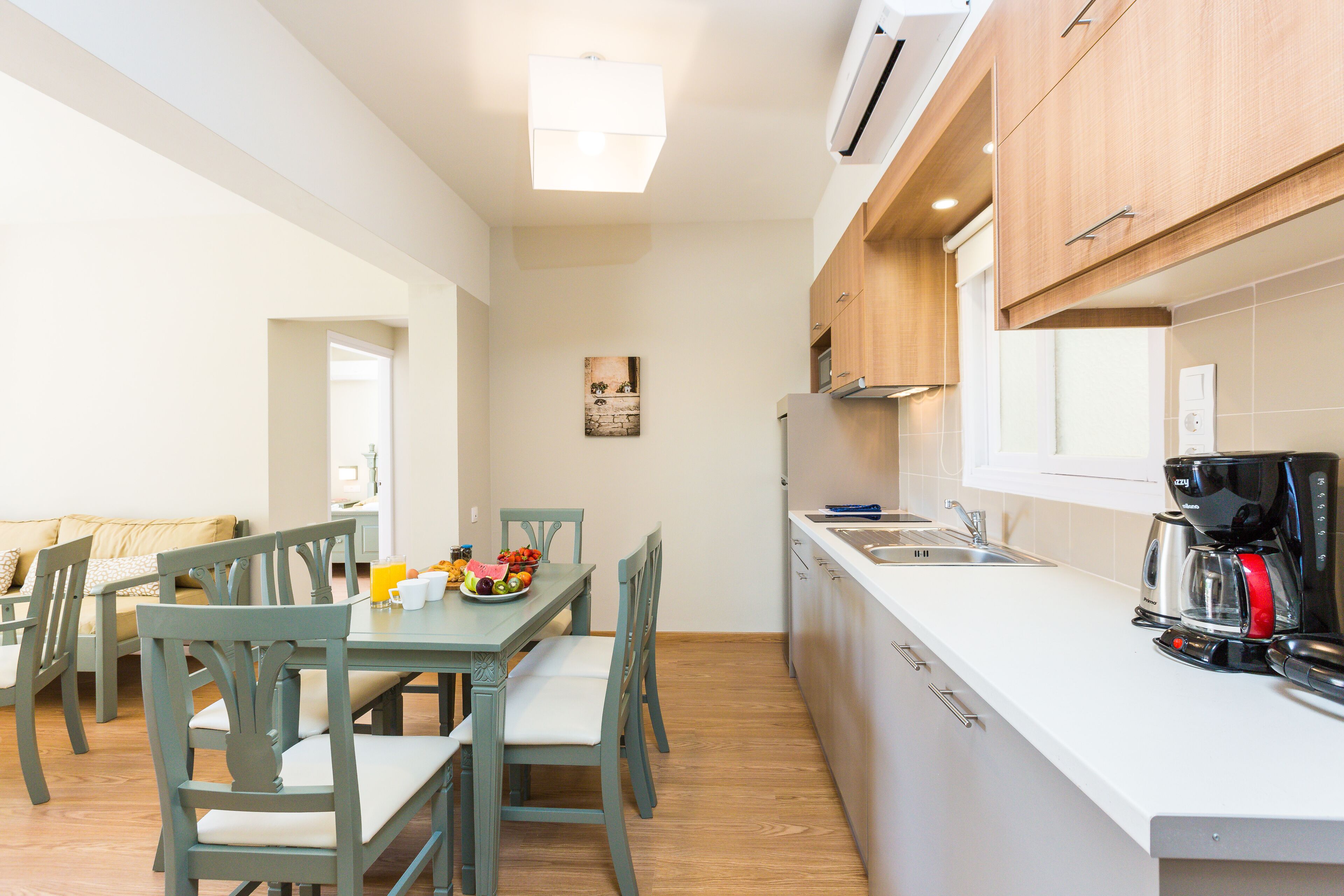 A compact kitchen with wooden cabinets, a white countertop, and a coffee maker.